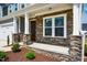 Inviting front porch with stacked stone columns and a charming front door entrance at 353 Murray Grey Ln, Wake Forest, NC 27587