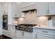 This cooking space includes a gas range, custom cabinetry, and modern backsplash at 353 Murray Grey Ln, Wake Forest, NC 27587