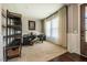Carpeted office space with a large window, shelving unit, and a work desk at 353 Murray Grey Ln, Wake Forest, NC 27587