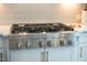 KitchenAid range with six burners atop white cabinetry and set against a decorative backsplash at 353 Murray Grey Ln, Wake Forest, NC 27587