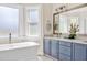 Bright bathroom features a double vanity with white countertop, tile flooring and natural light at 40 Farrells Creek Rd, Apex, NC 27523
