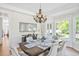 Bright dining room with bay window, hardwood floors, chandelier, and beautifully decorated table setting at 40 Farrells Creek Rd, Apex, NC 27523