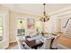 Bright dining room featuring large windows, hardwood floors, and a stylish chandelier with easy access to the staircase at 40 Farrells Creek Rd, Apex, NC 27523