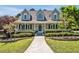Charming home with a welcoming front porch, complemented by lush greenery and colorful flowerbeds at 40 Farrells Creek Rd, Apex, NC 27523