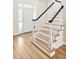 Bright foyer with hardwood flooring, staircase with black railing, and white front door at 40 Farrells Creek Rd, Apex, NC 27523