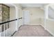Second floor hallway with carpet, wainscotting, white door, and stone accent wall at 40 Farrells Creek Rd, Apex, NC 27523
