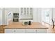 Bright kitchen with white cabinets, a wooden island countertop, and stainless steel appliances at 40 Farrells Creek Rd, Apex, NC 27523