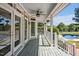 Relaxing covered porch with a ceiling fan, offering views of the serene backyard and swimming pool at 40 Farrells Creek Rd, Apex, NC 27523
