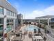 Relaxing rooftop pool and lounge area with tables, chairs, and lounge chairs overlooking city at 400 W North St # 1420, Raleigh, NC 27603