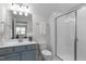 Bathroom featuring a blue vanity with quartz counters and a glass-enclosed shower at 421 Raven Cliff St, Apex, NC 27523