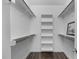 Walk-in closet featuring built-in shelving and wood laminate flooring at 421 Raven Cliff St, Apex, NC 27523