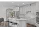 Well-lit kitchen with white cabinets, a center island with seating, and stainless steel appliances at 421 Raven Cliff St, Apex, NC 27523