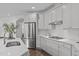 Bright kitchen featuring white cabinets, stainless steel appliances, and a quartz countertop island at 421 Raven Cliff St, Apex, NC 27523