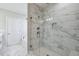Walk-in shower features white and gray tile, glass doors, and chrome shower fixtures at 4897 Grosbeak Ct, Mebane, NC 27302