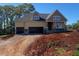 Unfinished two-story home featuring a three-car garage and dormer windows, set against a clear blue sky at 4897 Grosbeak Ct, Mebane, NC 27302