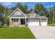 Charming two-story home with a covered porch, well-manicured lawn, and an attached two-car garage at 4897 Grosbeak Ct, Mebane, NC 27302
