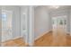 Bright hallway featuring hardwood floors and neutral paint, leading to various rooms in the home at 4897 Grosbeak Ct, Mebane, NC 27302