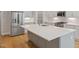 Stylish kitchen features a stainless steel refrigerator, island with quartz countertop and a view to a pantry at 4897 Grosbeak Ct, Mebane, NC 27302