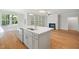 Open kitchen with center island, stainless appliances, and hardwood flooring offers abundant natural light at 4897 Grosbeak Ct, Mebane, NC 27302