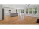 Open concept kitchen and dining area with hardwood floors, white cabinets, and lots of natural light at 4897 Grosbeak Ct, Mebane, NC 27302