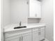 Laundry room with shaker cabinets, stainless steel sink, and granite countertops at 4897 Grosbeak Ct, Mebane, NC 27302