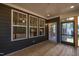 Enclosed outdoor area with wooden porch flooring, windows, and view of the backyard and neighborhood at 4897 Grosbeak Ct, Mebane, NC 27302