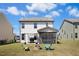 Spacious backyard featuring a well-maintained lawn, fire pit area, outdoor seating, and a view of the home's exterior at 509 Rose Creek Ct, Zebulon, NC 27597