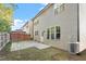Backyard featuring vinyl siding, a stone patio, a wooden fence, and an air conditioning unit at 5417 Razan St, Raleigh, NC 27616