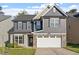 Charming two-story home with gray siding, stone accents, a two-car garage, and a well-maintained lawn at 5417 Razan St, Raleigh, NC 27616