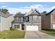 Charming home with gray siding, a stone facade, well-manicured lawn, and a two-car garage at 5417 Razan St, Raleigh, NC 27616