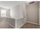 Upstairs hallway with neutral walls, plush carpeting, white trim, and a bright window at 5417 Razan St, Raleigh, NC 27616