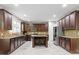 Spacious kitchen featuring dark cabinets, stainless steel appliances, and a convenient center island at 5417 Razan St, Raleigh, NC 27616