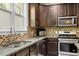 Kitchen with a stainless steel oven and microwave, granite counters and wood cabinets at 5417 Razan St, Raleigh, NC 27616