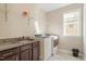 Functional laundry room with sink, cabinets, and modern washer/dryer for efficient chores at 5417 Razan St, Raleigh, NC 27616