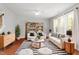 Bright and open living area with a cozy sofa, a unique striped rug, and an array of stylish decorative plants at 5417 Razan St, Raleigh, NC 27616