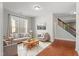Bright living room featuring hardwood floors, a large window, and neutral-toned furniture arranged on a patterned rug at 5417 Razan St, Raleigh, NC 27616