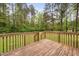 View of the wood deck leading out to the backyard with green grass and tall trees at 545 Irvan St, Clayton, NC 27520