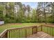 View of the back deck and a large backyard with green grass and mature trees at 545 Irvan St, Clayton, NC 27520