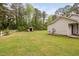 Large backyard with green grass, a small shed, and white fencing at 545 Irvan St, Clayton, NC 27520
