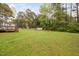 Wide backyard view showing the spacious lawn, deck, and a small storage shed, ideal for outdoor activities at 545 Irvan St, Clayton, NC 27520