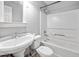 Bathroom with a pedestal sink, toilet, and a bathtub-shower combination with white tile surround at 545 Irvan St, Clayton, NC 27520