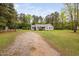 Charming home featuring a gravel driveway, well-maintained lawn, and a classic facade with blue shutters at 545 Irvan St, Clayton, NC 27520