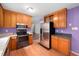 Functional kitchen equipped with stainless steel appliances and ample wood cabinet storage at 545 Irvan St, Clayton, NC 27520