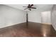 An empty living room with hardwood floors, a ceiling fan, and doors leading to other parts of the house at 545 Irvan St, Clayton, NC 27520