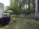 Grassy backyard featuring mature trees, a grill, and a fenced perimeter at 5515 S Roxboro St # 16, Durham, NC 27713