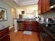 Open kitchen with stainless steel dishwasher, granite countertop, and hardwood floors at 5515 S Roxboro St # 16, Durham, NC 27713