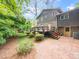 Backyard featuring a brick patio, deck and lush greenery, creating a private and inviting outdoor space at 5816 Old Forge Cir, Raleigh, NC 27609