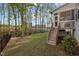 Landscaped backyard with black fence, steps to screen porch, and mature trees at 604 Craftsman Ridge Trail, Knightdale, NC 27545
