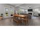 Open-concept dining room featuring a wooden table and bench with access to the living room and outdoor patio at 604 Craftsman Ridge Trail, Knightdale, NC 27545