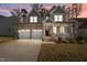 Charming two-story home featuring a stone and gray shingle exterior with a two-car garage and inviting front porch at 604 Craftsman Ridge Trail, Knightdale, NC 27545